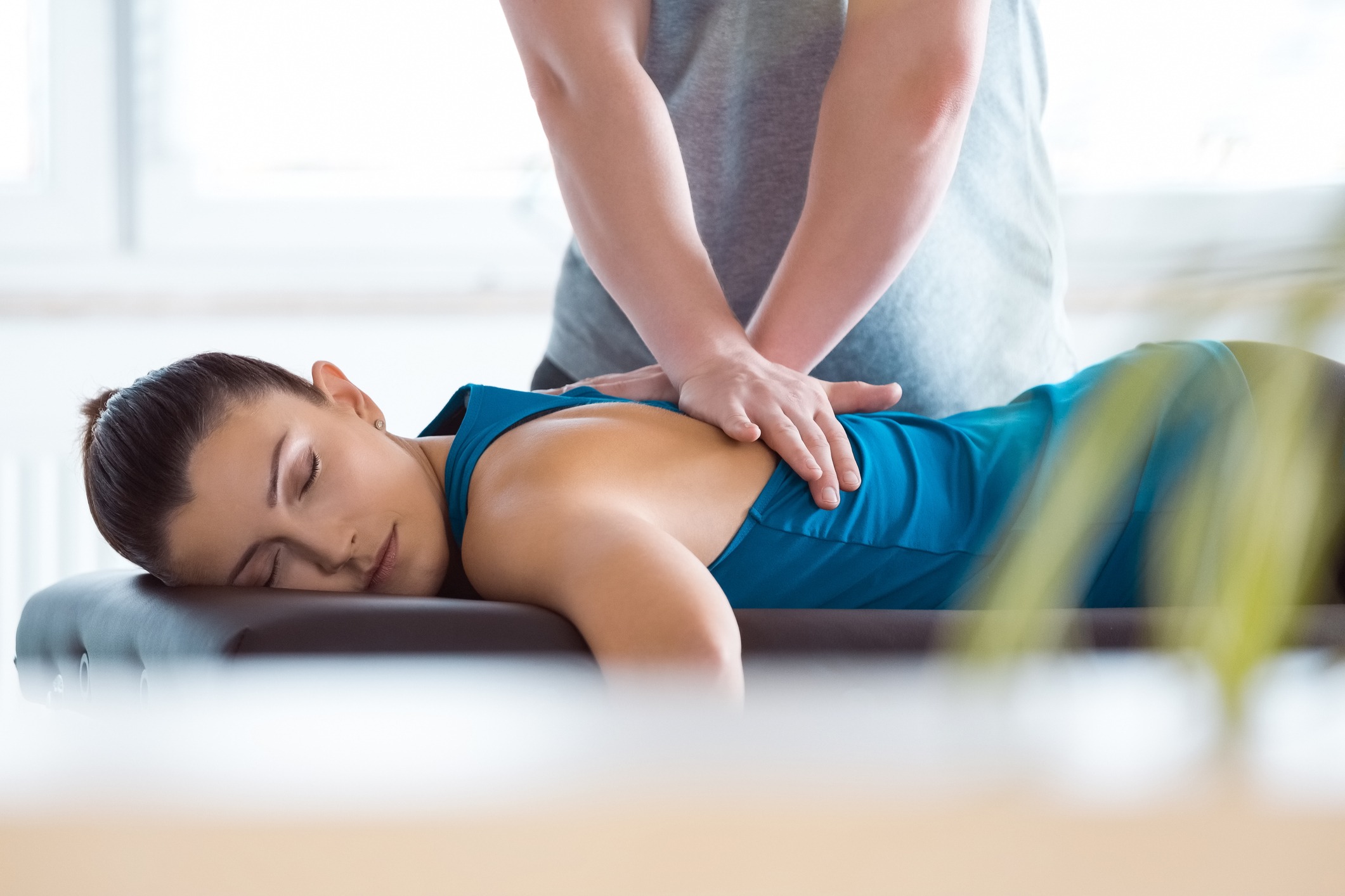 Physiotherapist massaging young woman